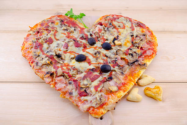 istock Heart shaped pizza on wood 464666086