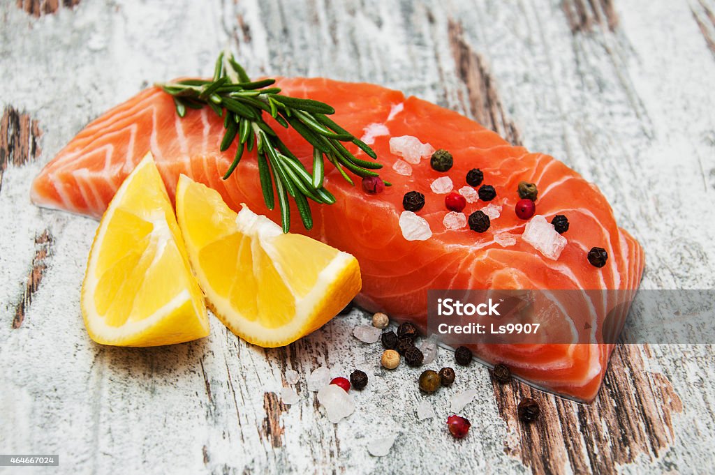 portions of fresh salmon fillet portions of fresh salmon fillet with aromatic herbs, spices and lemons 2015 Stock Photo