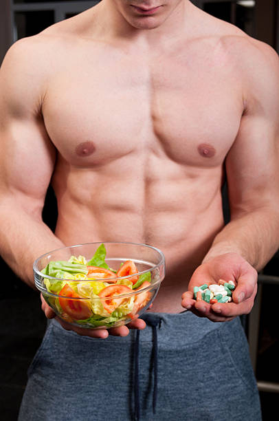 istock Fit male chosing between pills and natural salad 464667094