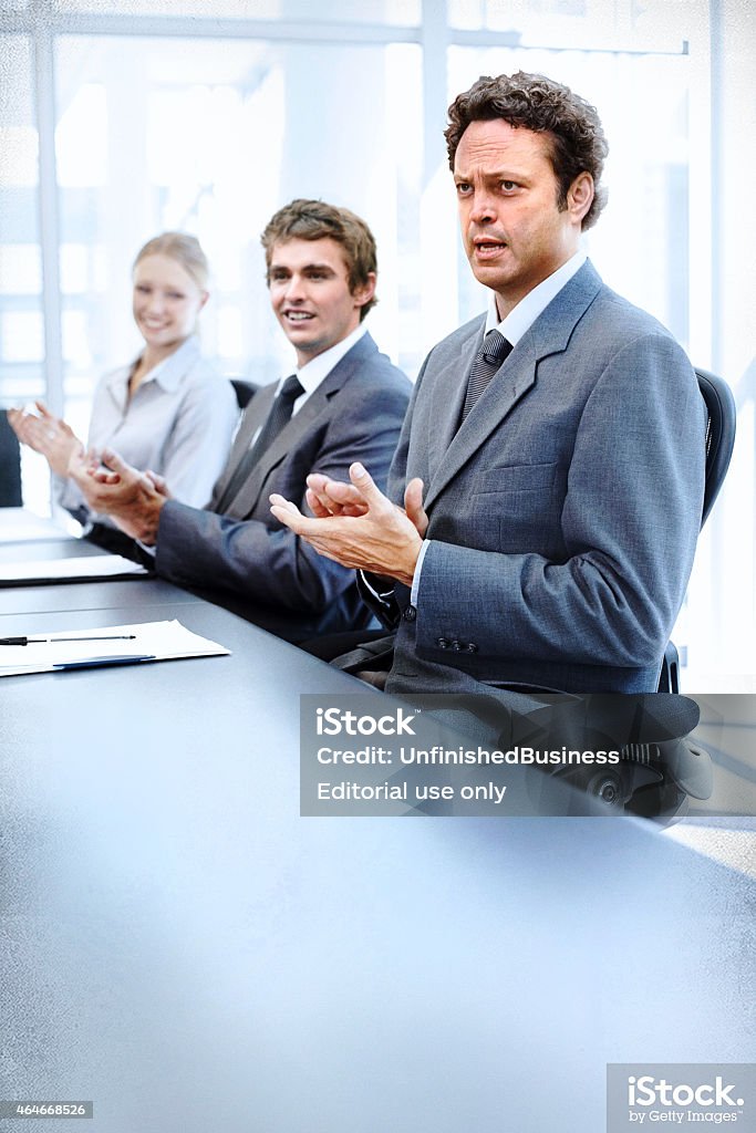 Dan Trunkman applauds a successful meeting Dan Trunkman and Mike Pancake applaud a successful business program in Unfinshed Business. In theaters March 6, 2015. Photography Stock Photo