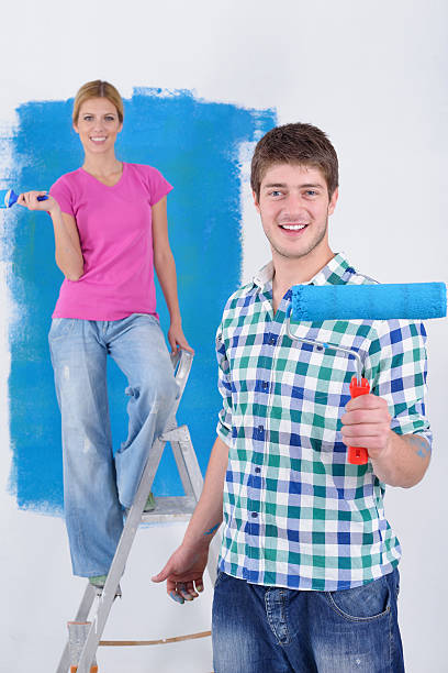 istock happy couple paint wall at new home 464670007