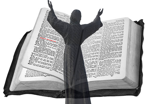 prayer man hand on Bible on dark room. bible in hand. The inscription on the book translated from Russian: the Bible