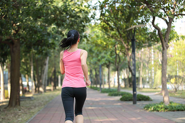 istock woman morning exercise jogging at park 464676441