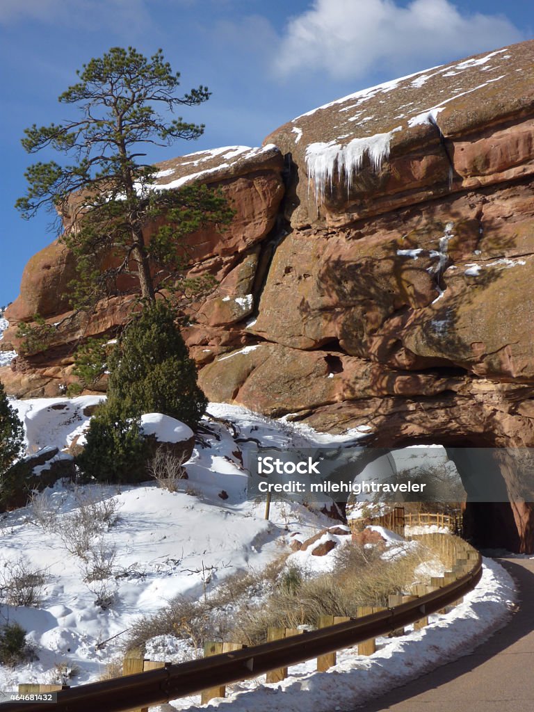 Snow and icicles on Red Rocks Park and Ampitheater Colorado Icicles hang off the red rock cliff edge over the tunnel though a snow covered Red Rocks Park and Ampitheater just outside Denver, Colorado. 2015 Stock Photo