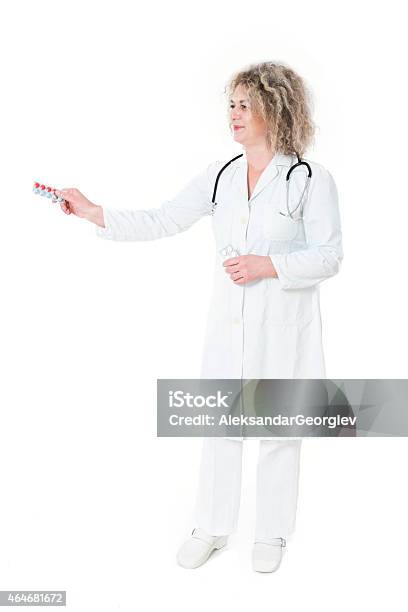 Mature Smiling Women Doctor Prescribing Medicine And Giving White Pills Stock Photo - Download Image Now