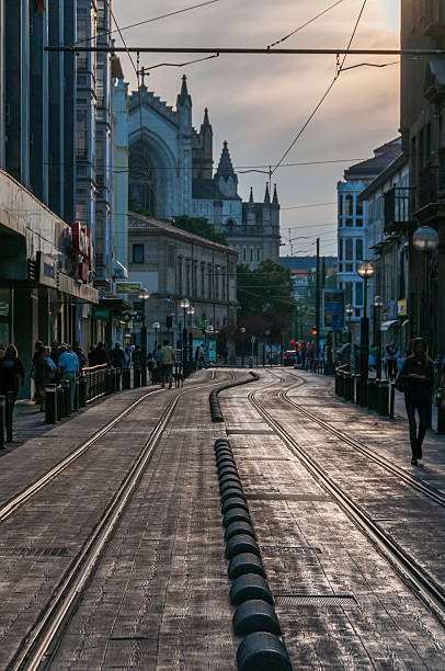 Vitoria-Gasteiz, Euskadi, Spain - July 29, 2011: Sunset in Vitoria-Gasteiz. Overview Calf Bengoa Kalea, backlit, with the facade of the Cathedral of Mary Immaculate in the background. Several people walking on the sidewalks.