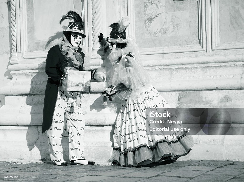 Venice Carnival 2015 Venice, Italy - February 9, 2015: The photo was taken during the famous Venice carnival on Campo San Zaccaria in front the church. We can see couple of masked person in black and white carnival costume . Venice, Italy.  2015 Stock Photo