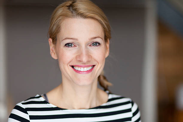 Close up Of A Smiling Italian blond woman Close up Of A Smiling blond woman wearing a striped shirt mediterranean woman portrait stock pictures, royalty-free photos & images