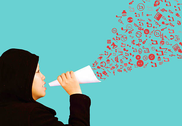 Woman blowing the icons out from paper megaphone