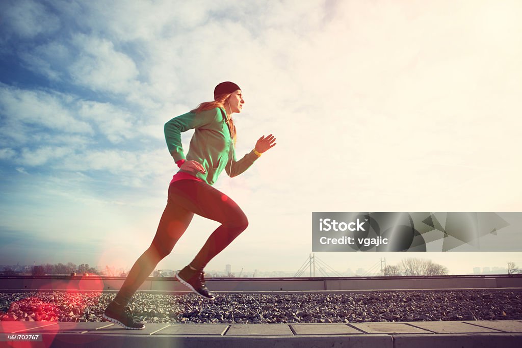 Mujer correr en puente con cityscape behind - Foto de stock de Otoño libre de derechos