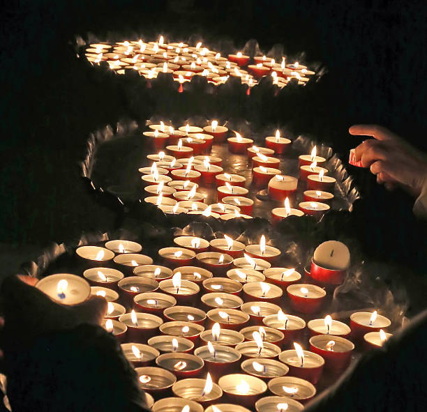 istock young faithful hand lights a candle 464712730