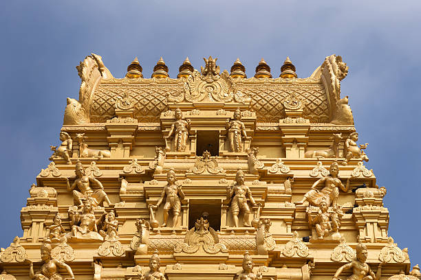 Top of golden tower at Sri Nageshwara in Bangalore. Plenty of golden statues on the top of the entrance tower at Sri Naheshwara in Bengaluru. The statues are painted in a golden-beige tint and are not actually gold. lingam yoni stock pictures, royalty-free photos & images