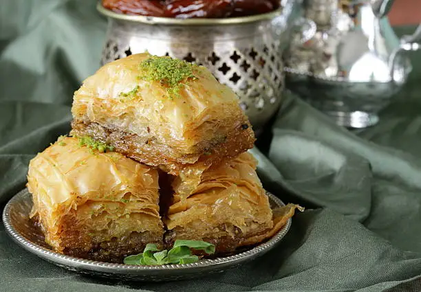 Turkish arabic dessert baklava with honey and nuts on a silver plate