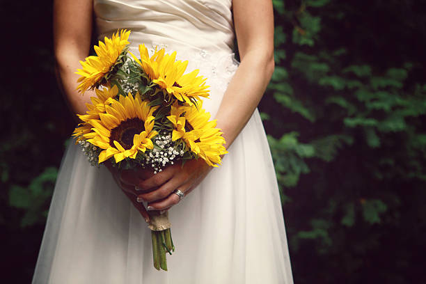 невеста, держа букет «подсолнухи» - bride women standing beauty in nature стоковые фото и изображения