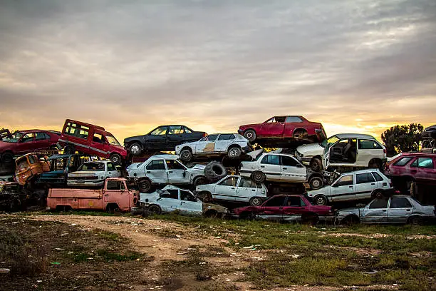  Stack of damaged rusted car scraps on junkyard