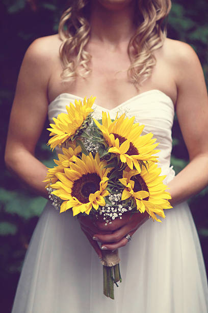 невеста, держа букет «подсолнухи» - bride women standing beauty in nature стоковые фото и изображения