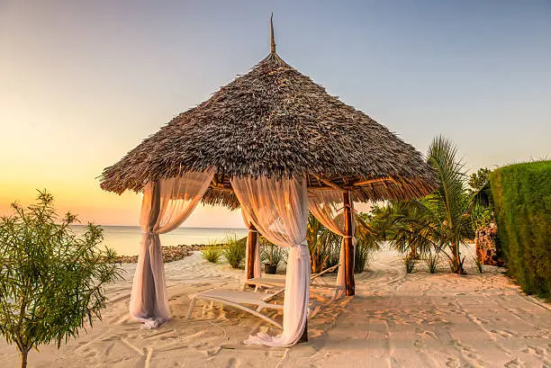 Beach lounge chairs at sunset at the shore of Indian ocean, Zanzibar, Tanzania