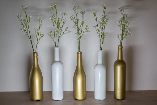 Interior decor, gold and white wine bottles with stems.
