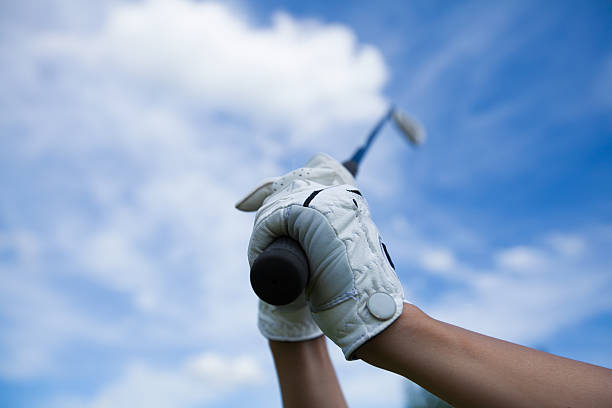 istock golfer hands in gloves holding iron in the sky 464736792