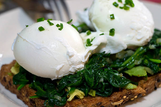 Poached egg on whole grain toast with avocado and spinach