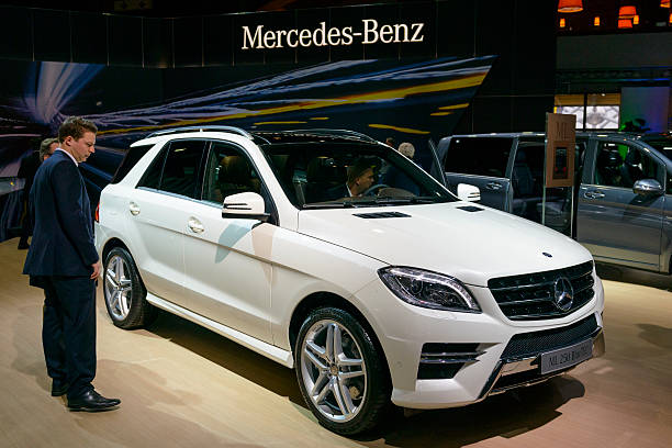 Brussels, Belgium - January 15, 2015: Mercedes Benz M-class ML 250 BlueTec SUV on display during the 2015 Brussels motor show. People in the background are looking at the cars.