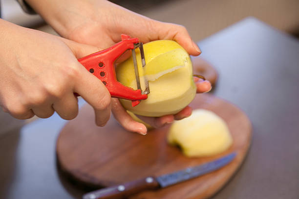 hand peeling apple stock photo