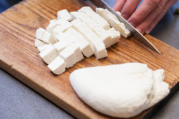 Cutting paneer into pieces stock photo