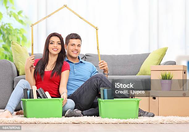 Young Couple Sitting In A Living Room Stock Photo - Download Image Now - 20-29 Years, 2015, Adult