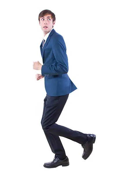 young caucasian businessman running away from imaginary threat.  The handsome male entrepreneur is performing generic actions for composites.  He is isolated on a white background.  He is wearing a business suit and depicts the corporate business industry.