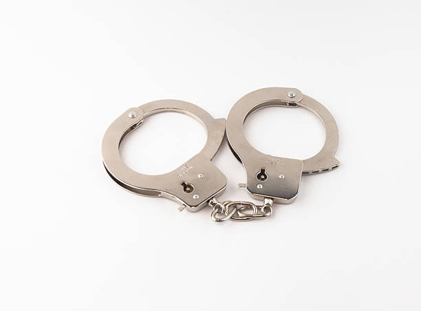 istock Steel handcuffs on a green background 464773394