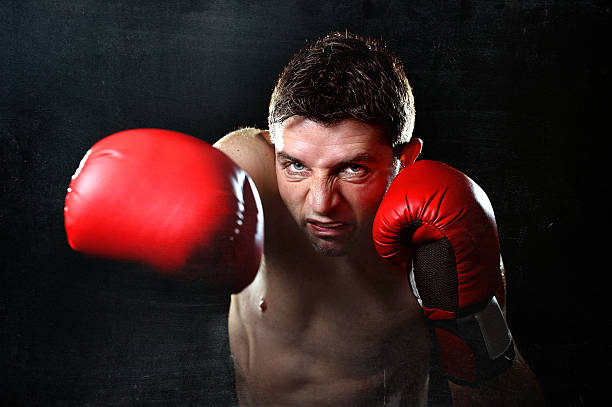 istock angry man boxing throwing vicious right hand punch in gym 464775906