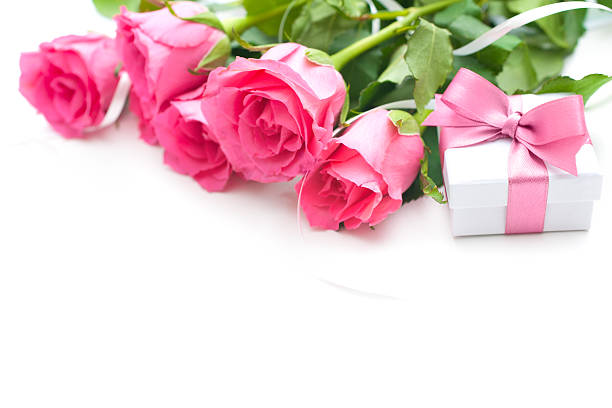 Bouquet of roses and gift box on white background