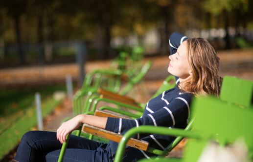Girl in a Parisian park enjoying sunny day