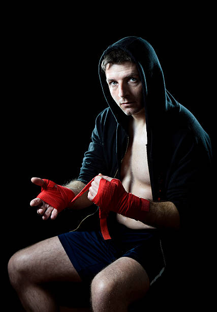 istock man in boxing hood wrapping hands wrists before fighting 464780180