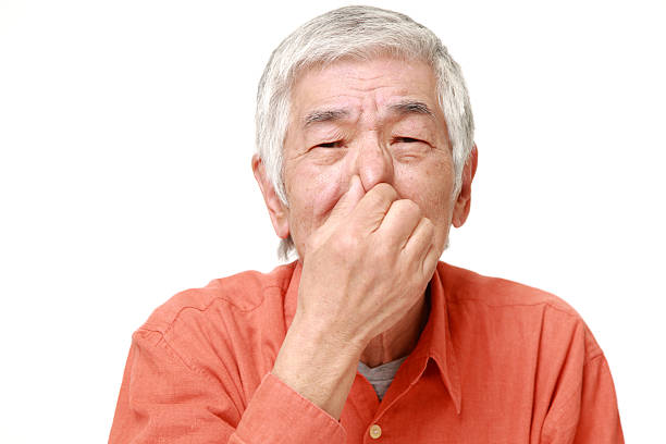 istock senior Japanese man holding his nose 464780826