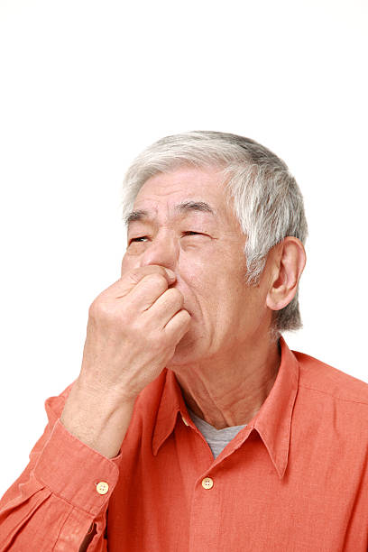 istock senior Japanese man holding his nose 464780828
