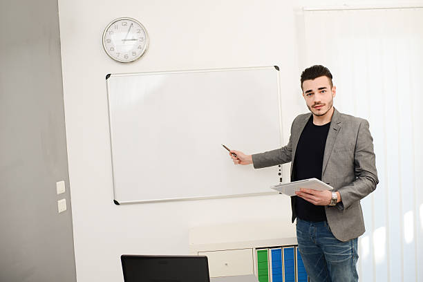 istock young business man or teacher showing data on white board 464783150