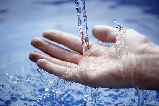 istock Hand extended under running water above pool of water. 464789466