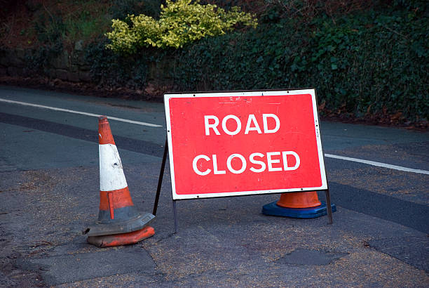 Road closed sign Sign and cones indicating that the road ahead is closed. road closed sign horizontal road nobody stock pictures, royalty-free photos & images