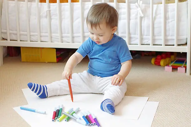 lovely baby age of 1 year paints with felt-pens
