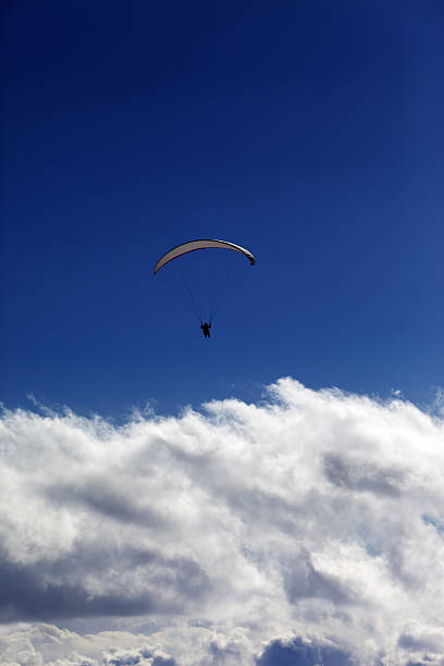istock Silhouette of paraglider and blue sky with clouds 464790825