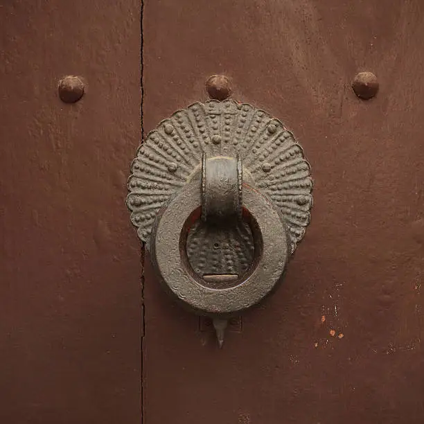 Ancient round doorhandle on a wooden door