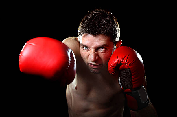 istock angry man boxing throwing vicious right hand punch in gym 464793112