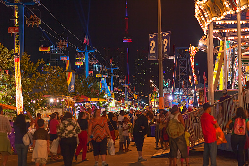 Toronto, Ontario, Canada - September 2, 2012: This is a photo depicting a general scene at the Canadian National Exhibition which is an annual event hosted in Toronto in late summer. You can see a crowd of people walking through the various venues at the event and the Toronto skyline in the background including the CNTower. The focus is on the LOT 2 sign.