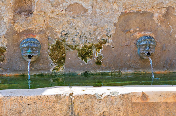 Tuscania (Lazio), Italy: Piazza Duomo with a fountain (Fontana Grande) dating from the 1600s (with a jet of water) and the Duomo, dating from the 1500s. Founded by the Etruscans, the ancient town is in the Lazio, province of Viterbo.