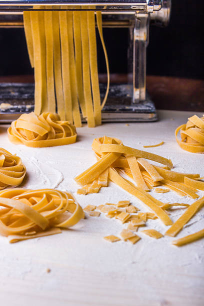 istock Homemade noodles and pasta machine on a wooden table 464799462