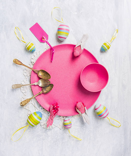 istock Pink plate with Easter eggs, spoons, ribbons and sign 464801552