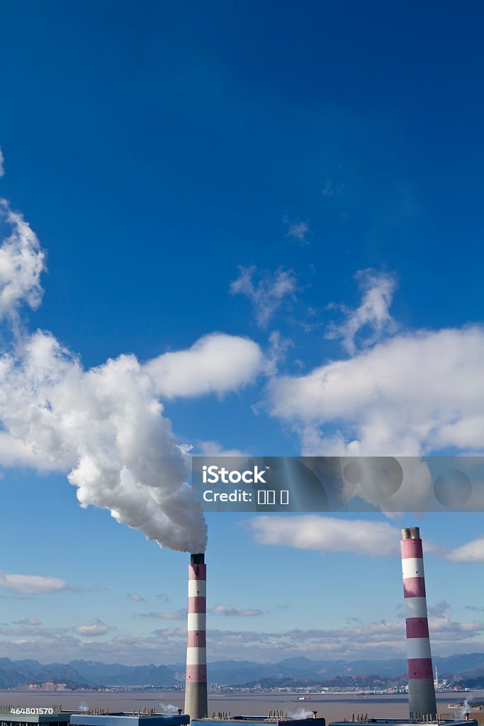 Smokestack and Gas Emissions  Against Blue Sky. Industrial chimney or smokestack emitting gases . 2015 Stock Photo