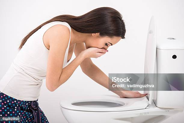 Woman In Pajamas About To Vomit Into A Toilet Stock Photo - Download Image Now - Bulimia, 2015, Adult