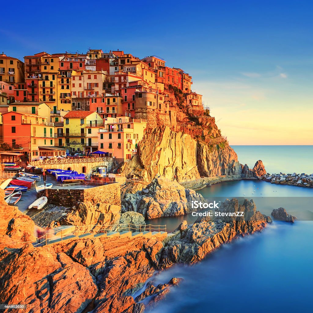 Manarola village, rocks and sea at sunset. Cinque Terre, Italy Manarola village on cliff rocks and sea at sunset., Seascape in Five lands, Cinque Terre National Park, Liguria Italy Europe. Square format. Long Exposure Cinque Terre Stock Photo